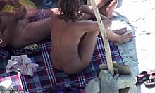 美丽的棕发女郎在裸体海滩上展示她的裸体。